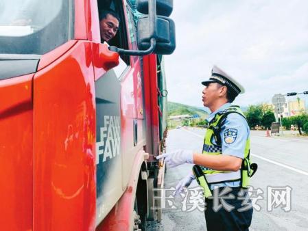 玉溪市公安局高速公路交巡警大队大风垭口中队中队长胡锦文在提醒过往车辆驾驶员减速慢行。